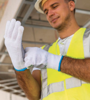 Worker putting on safety gloves